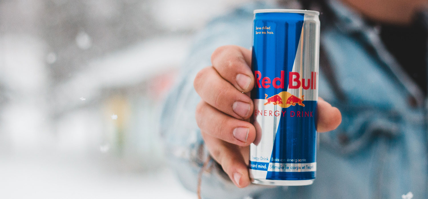 Mann hält eine Dose Red Bull ins Bild