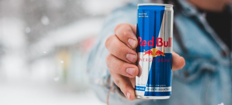 Mann hält eine Dose Red Bull ins Bild
